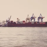 Navă de transport marfă și containere în terminalul unui port comercial