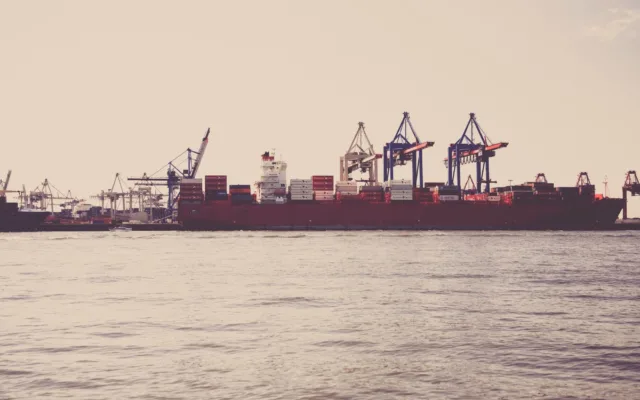 Navă de transport marfă și containere în terminalul unui port comercial